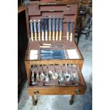 An early 20th century oak canteen and contents, a twelve place setting, 50cm wide.