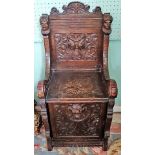 A carved oak porter's chair, having stylized figure and bird decoration, 48cm wide.