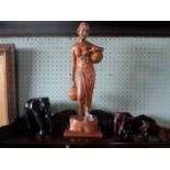 A large carved hardwood figure of a lady carrying water, 52cm, together with four carved animals.