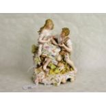 A 19th century porcelain figure group, seated couple with a lamb, having applied floral decoration,