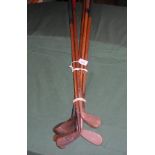A collection of five golf clubs, 20th century, each with wooden shaft,