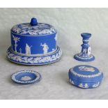 Three items of Wedgwood blue Jasperware, to include: candlestick, covered dish and a pin dish,