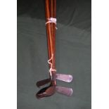 A collection of five golf clubs, 20th century, each with wooden shaft,