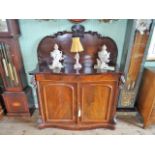 A Victorian mahogany serpentine fronted chiffonier, having scroll back over two cupboard doors,