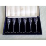 A late 19th century set of six drinking glasses, having air twist stems, in a fitted leather case,