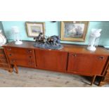 A circa 1970's G-Plan style sideboard, having three drawers beside two cupboard doors, 199cm wide.
