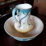 An Edwardian washbowl and jug, having hand painted floral decoration with blue relief borders,