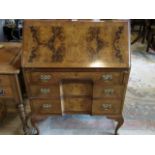 A walnut veneered three drawer bureau on front cabriole supports, 76cm wide.