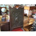 An early 20th century oak framed fire screen, inset with metalware panel in the Art Nouveau manner,