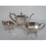 A three piece Art Deco silver tea set, comprising: teapot, twin handled sugar bowl and milk jug,