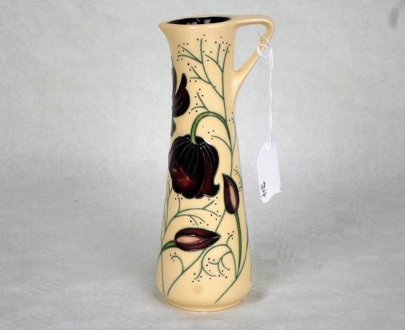 A contemporary Moorcroft small jug, having tube-lined decoration of purple flowers,