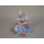 A 20th century Zsolnay Pecs ceramic figurine of a seated girl with a goose,