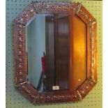 An Arts & Crafts-style mirror, having beaten copper relief decoration to the border,