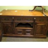 A large Victorian walnut sideboard, having three drawers over central recess and two cupboard doors,