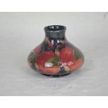 An early 20th century William Moorcroft squat vase, in the Pomegranate pattern, 10.5cm tall (AF).