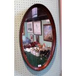 A mahogany framed oval wall mirror, 76cm x 46cm.