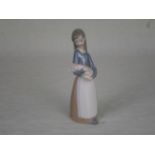 A Lladro figurine of a girl holding a piglet, number 1011, 17.5cm.