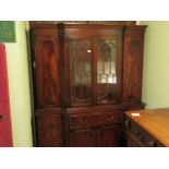 A reproduction mahogany wall unit, the central glazed doors flanked by cupboard doors,