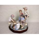 A large Nao figure group, children playing cards, mounted to bespoke wooden stand, 34cm tall.