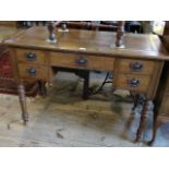 An Edwardian oak five drawer desk on turned supports, 106cm wide.