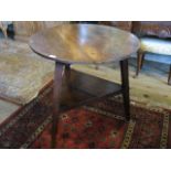 An early 20th century oak circular table, having triangular undertier on out-swept supports,