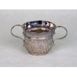 A Queen Anne silver porringer, having part-fluted decoration with reeded scroll handles,