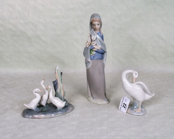 A Lladro figurine of a lady carrying flowers, together with two further Lladro bird figure groups.