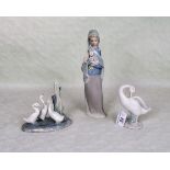 A Lladro figurine of a lady carrying flowers, together with two further Lladro bird figure groups.
