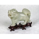 A Chinese pale celadon jade study of a lion, the body having extensive decoration,