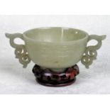 A Chinese pale celadon jade libation cup, the twin handles of scroll form,