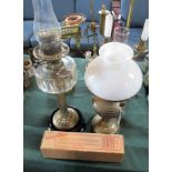 Two brass oil lamps, one having a clear glass reservoir, the tallest 68cm.