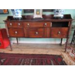 An early 19th century mahogany sideboard, having brass lion handles on rope twist supports,