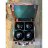 An early 20th century leather case set of four lawn bowls signed Thomas Taylor, Glasgow.