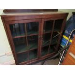 A mid-20th century two door bookcase on turned and block supports, 91cm wide.