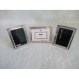 Three silver picture frames.