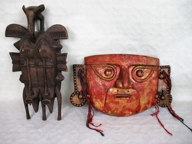 An African carved tribal wall mask, formed as two conjoined faces with bird finial, 37cm,