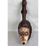 An African tribal mask, having white painted face, within a basket weave frame, 53cm.