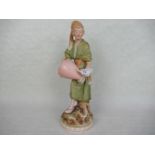 A Royal Dux porcelain figurine, a young boy carrying a water urn, mounted to circular plinth,