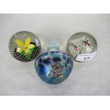 A Caithness glass paperweight titled 'Petals', together with two further paperweights.
