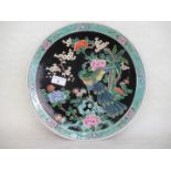 A 20th century Oriental plate, having polychrome decoration depicting a bird amongst trees,