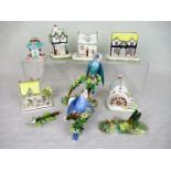 A Crown Staffordshire ceramic budgerigar, perched on flower encrusted stump,