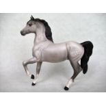 A Beswick model of a grey prancing horse, 17cm.