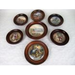 A collection of seven Pratt Ware pot lids, each in turned wooden circular frame,