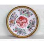 A late 19th century Chinese porcelain charger, centrally decorated with an Imperial dragon,