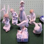 A collection of eight Nao porcelain figures, including: rabbits in a basket, girl with puppy, swan,