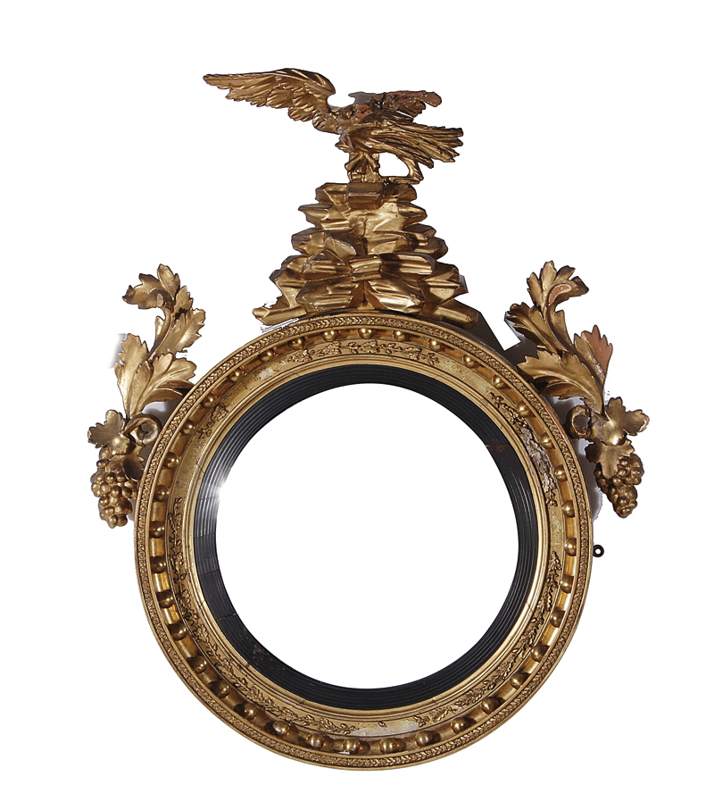 Regency carved giltwood bull's-eye mirror first quarter 19th century, eagle pediment and leaf