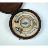 An early 20th century circular combination mercury thermometer and compass, mounted on ivorine, in a