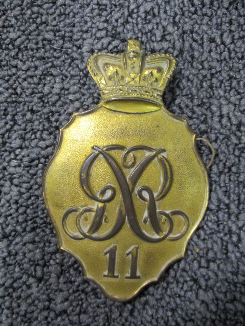 A George III copper-gilt shako plate, with crown over royal cypher and No. 11 for the North