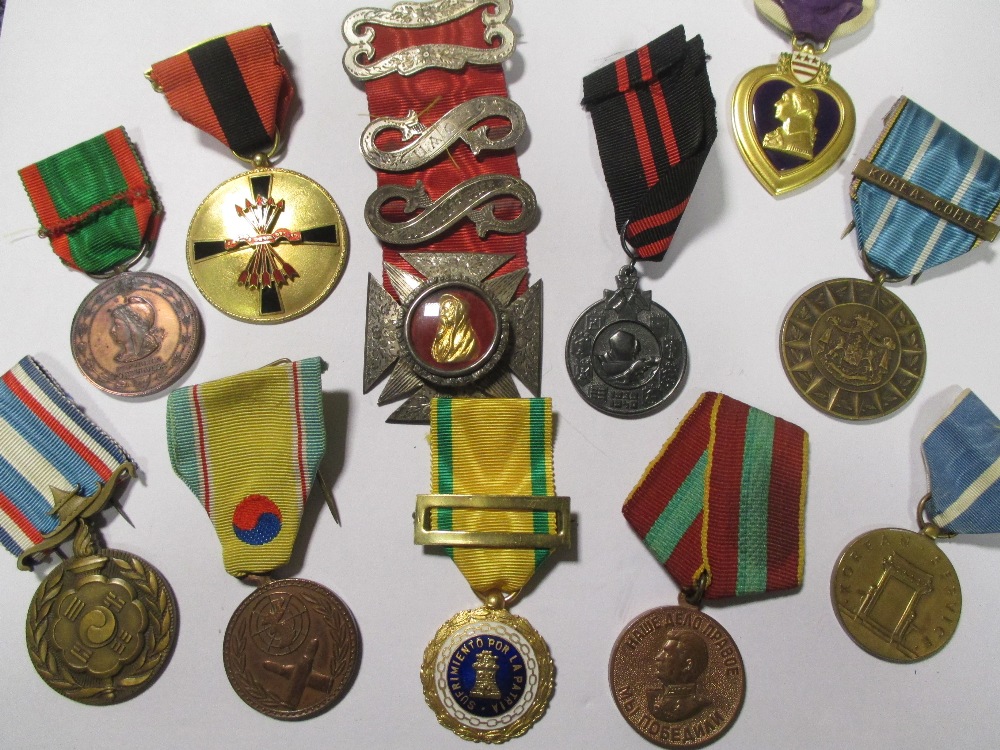 A collection of world medals, to include a Korean War service medal, a US purple heart, a US