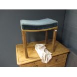 An Elizabeth II 1953 Coronation stool, upholstered in blue velvet on chamfered oak legs, with fitted